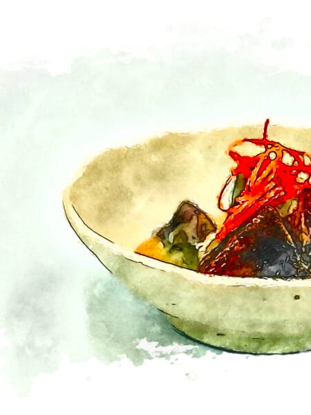 Fuyu persimmon with sesame cream and a garnish of its own skin in an off-white bowl.