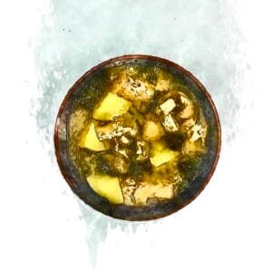 A wooden bowl filled with piping hot potato and seaweed miso soup.